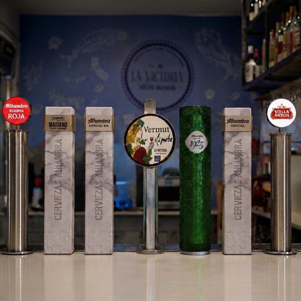 Fila de grifos de cerveza en la barra de La Victoria, frente al mural del restaurante