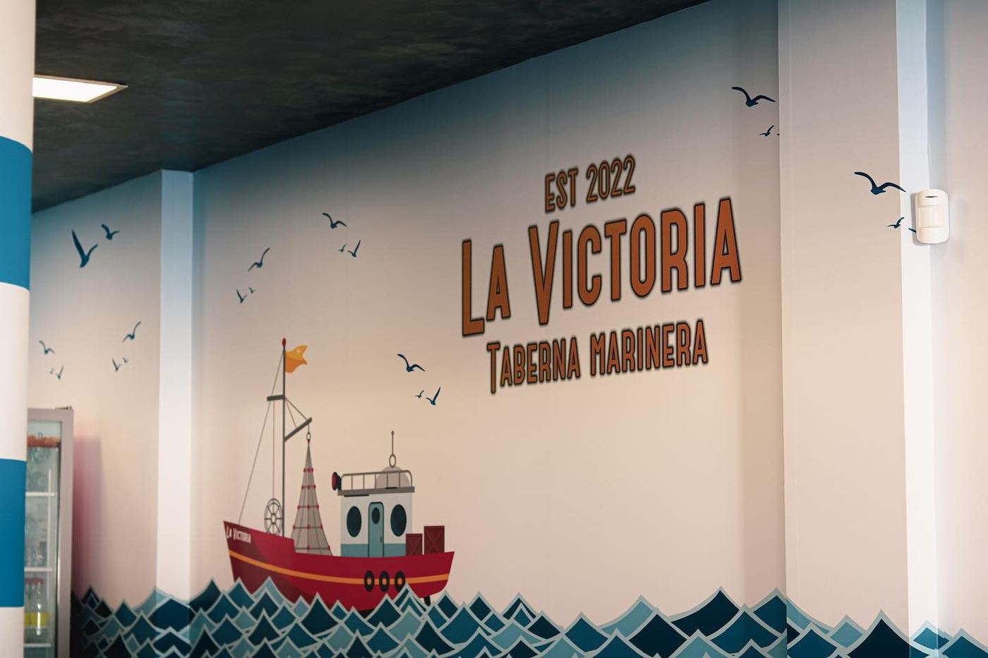 Mural de bienvenida de La Victoria, Taberna Marinera, en la entrada del restaurante